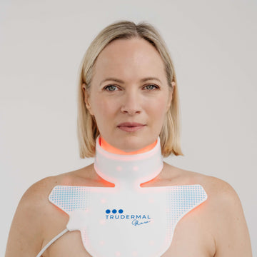 Woman wearing Glow LED Neck + Décolletage mask for skin rejuvenation and wrinkle reduction.