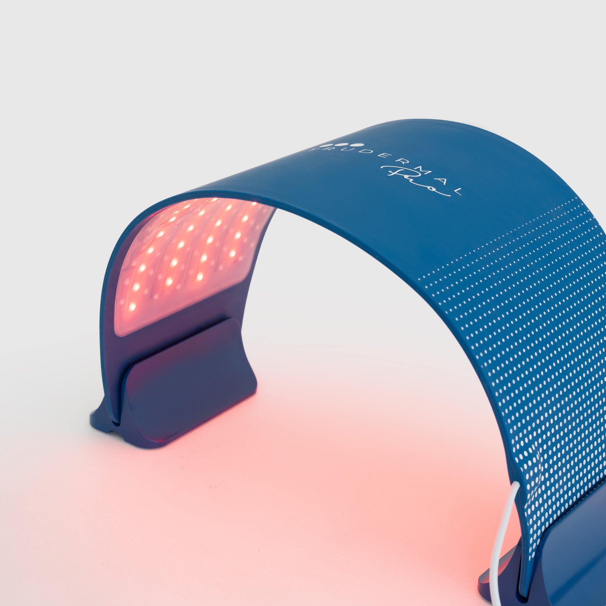 Woman receiving red light therapy treatment under Trudermal Pro to support collagen production and improve skin texture.
