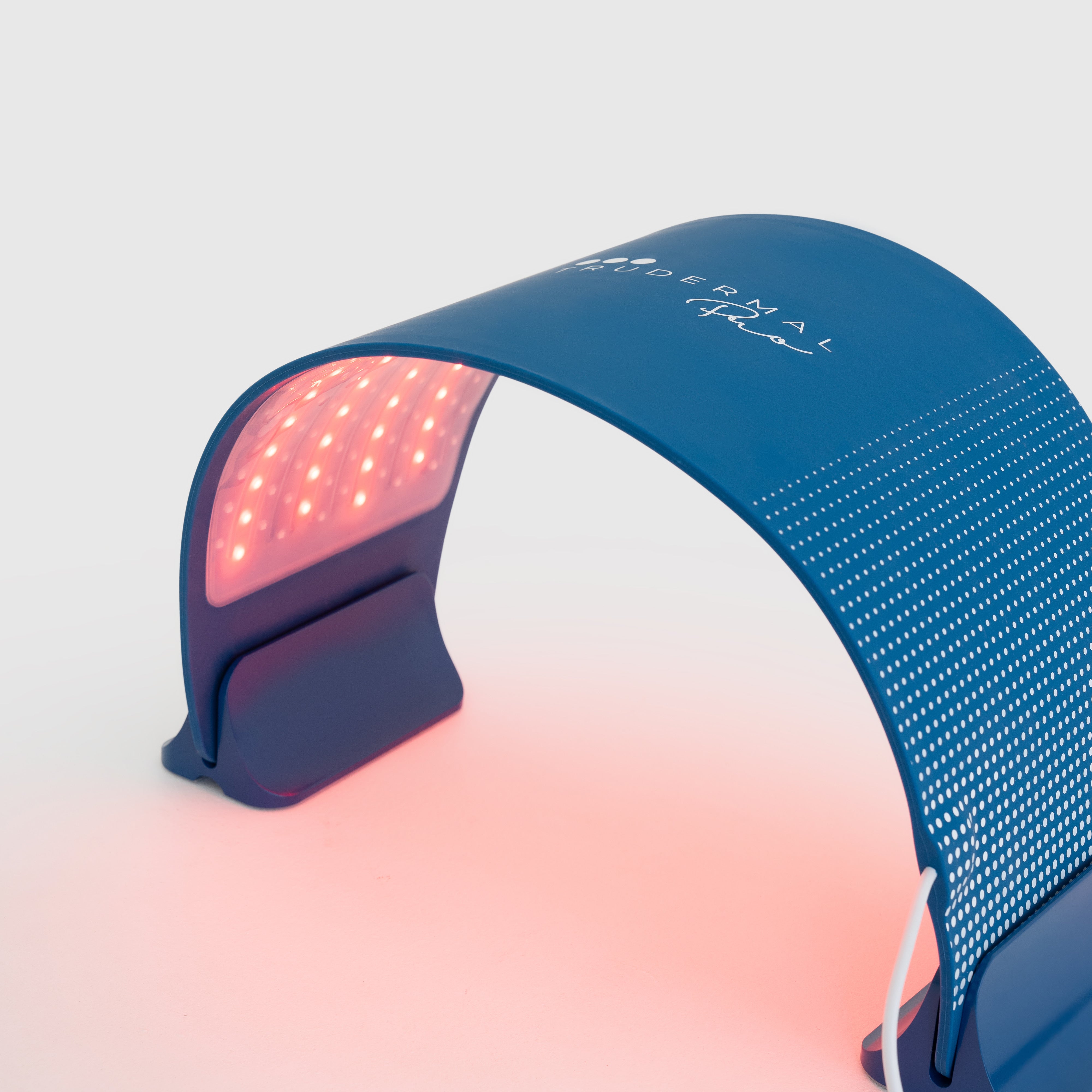 Woman receiving red light therapy treatment under Trudermal Pro to support collagen production and improve skin texture.