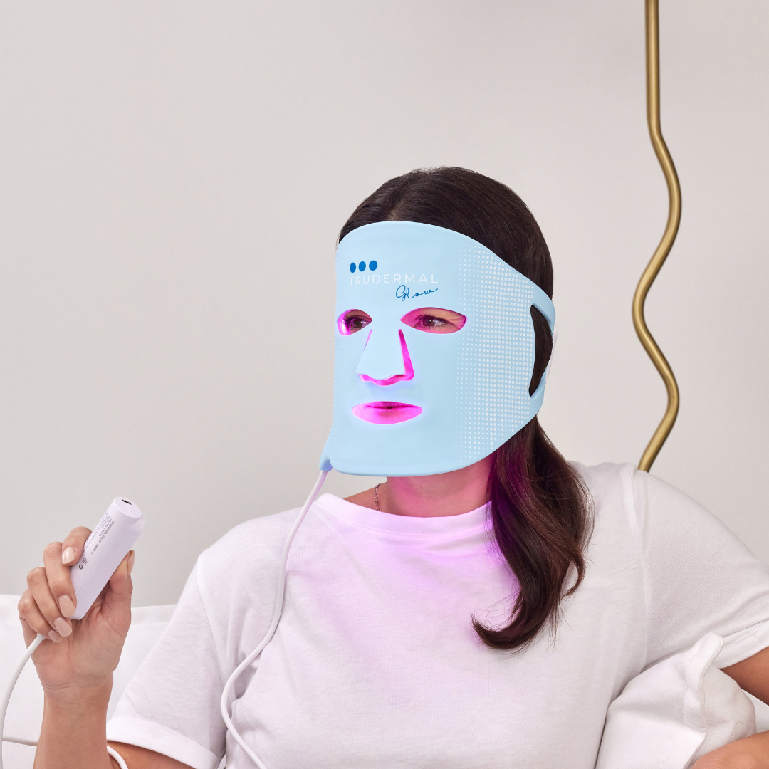 Woman wearing LED light therapy face mask designed to boost collagen and improve skin clarity.